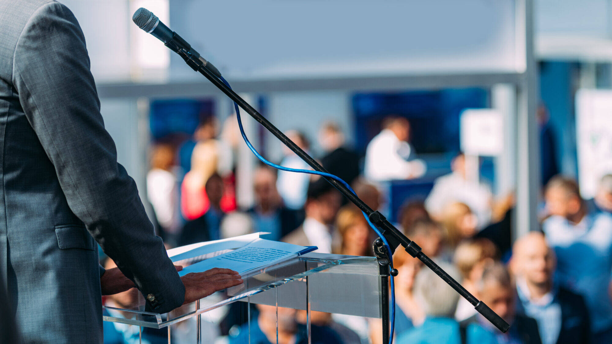 Male Speaker Standing In Front Of Microphones Male Speaker Standing In Front Of Microphones