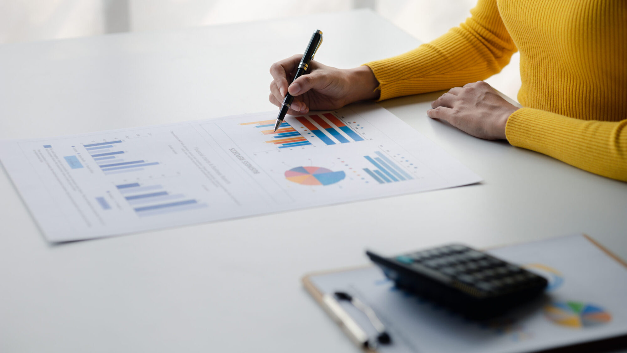 A female financier is reviewing company financial documents, mon