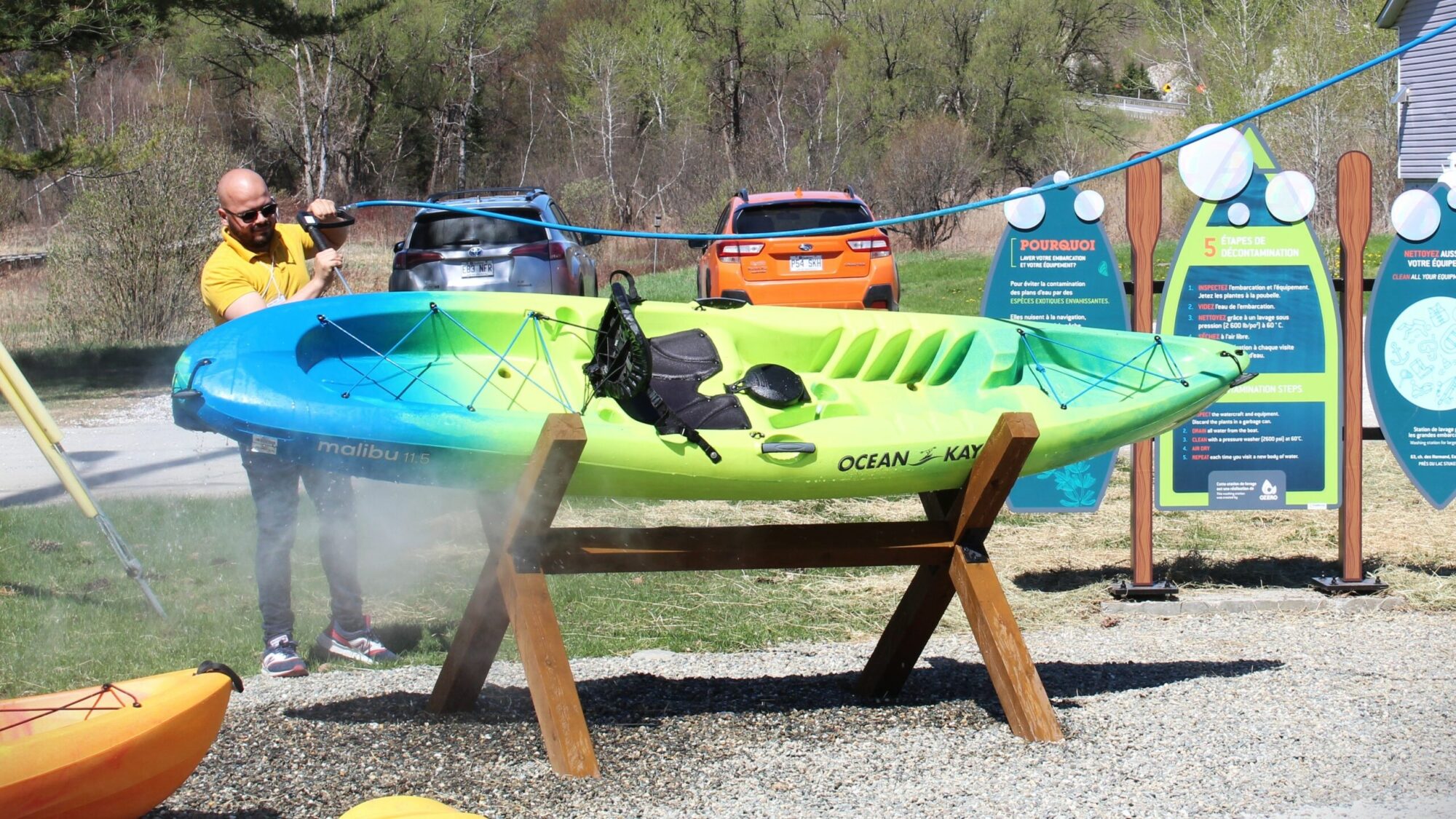 Un-homme-nettoie-un-kayak-scaled