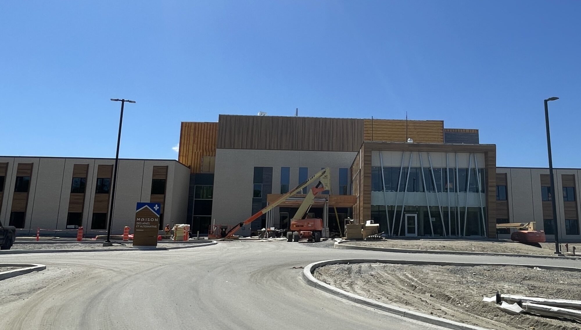 Un bâtiment du Centre intégré de santé et de services sociaux de l'Outaouais en travaux , avec de la machinerie lourde à l'avant-plan.