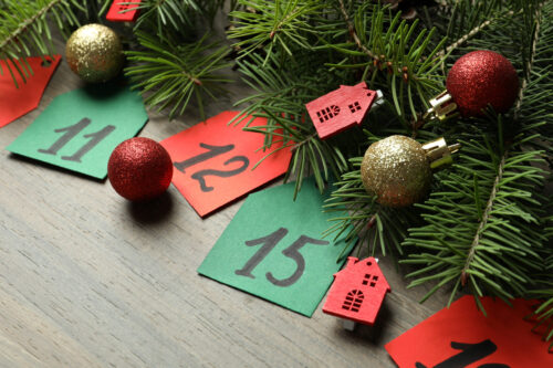 Calendrier de l'Avent sur fond de planche en bois et sapin avec décoration des Fêtes.