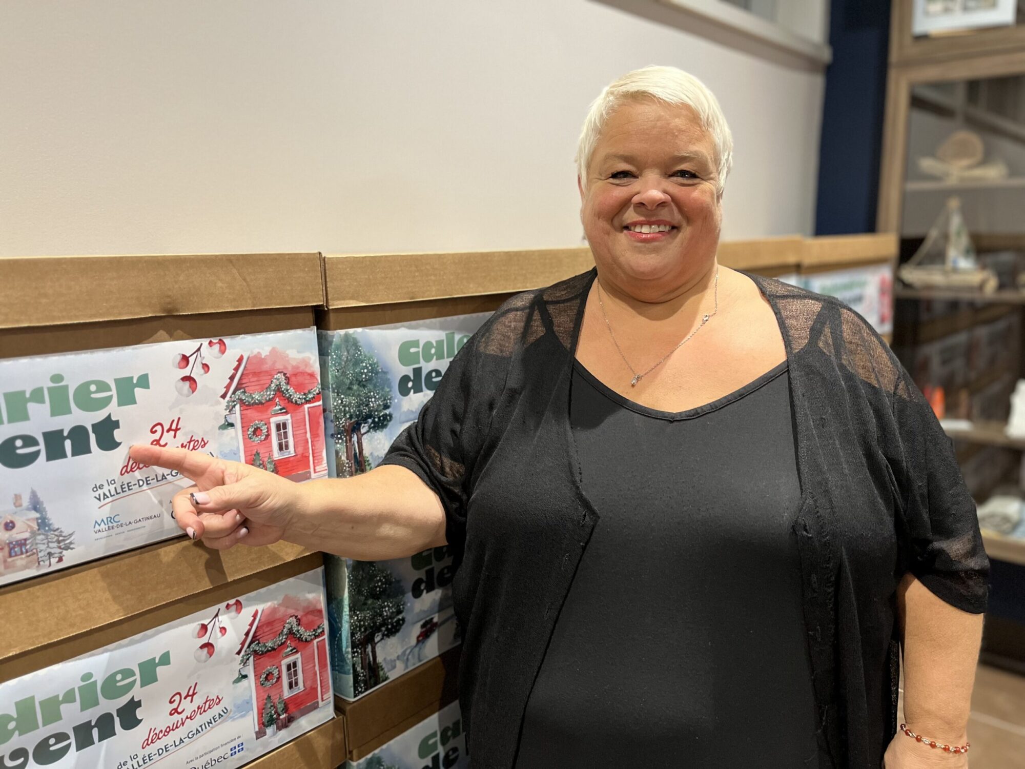 La préfète de la MRC de La Vallée-de-la-Gatineau, Chantal Lamarche, pointe du doigt une boîte contenant des produits locaux.