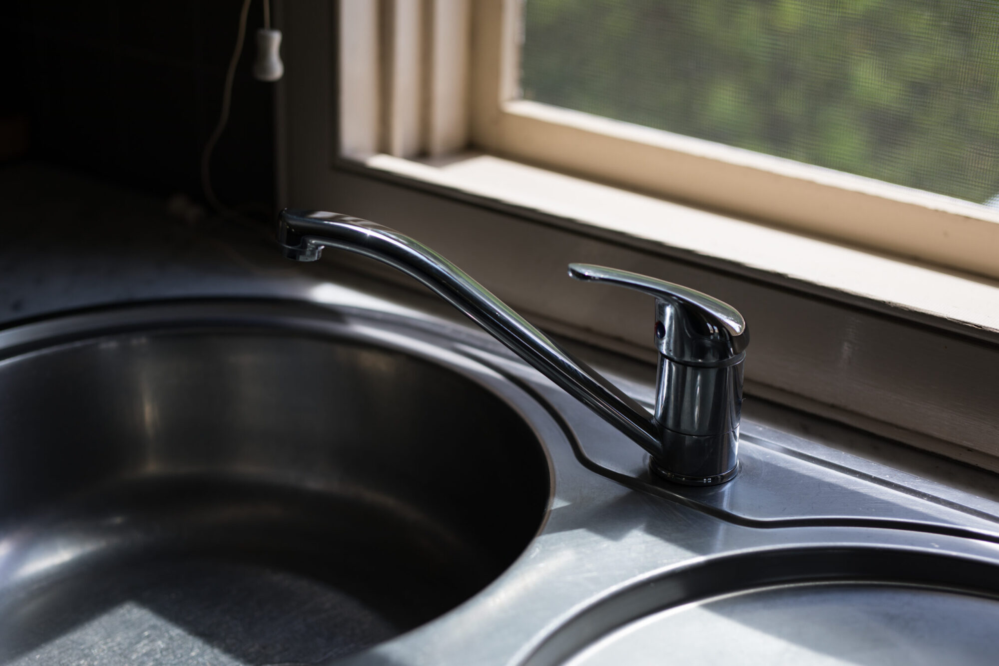 Un évier de cuisine près d'une fenêtre.