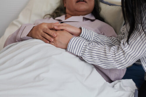 Daughter Touching Hands of Sick Mother