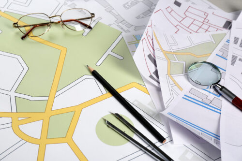 Office stationery and eyeglasses on cadastral maps of territory