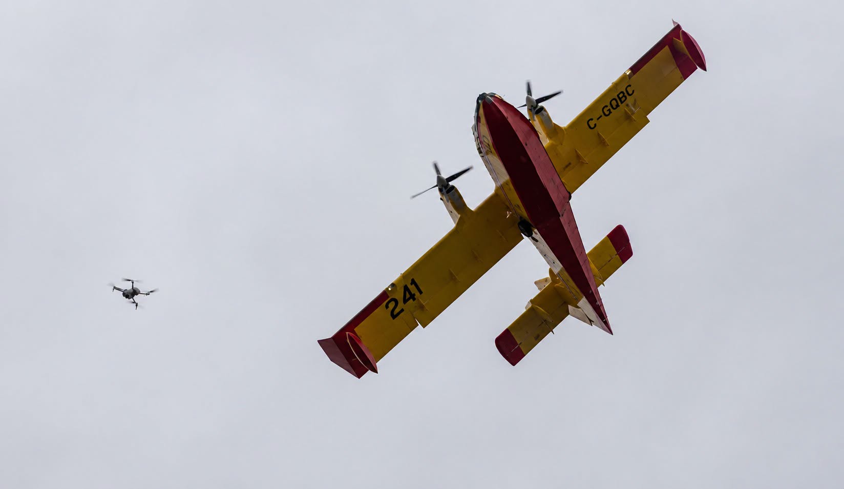 Un drone vole à proximité d'un avion-citerne de la Société de protection de la forêt contre le feu.