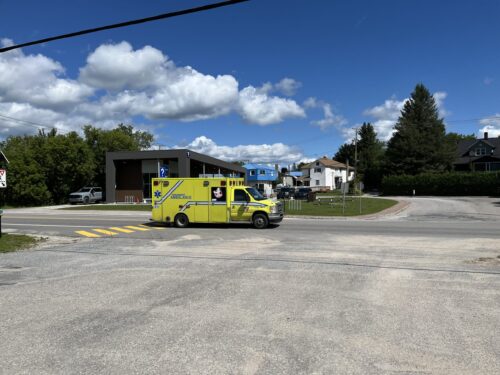 Une ambulance circule sur une route dans une agglomération au Québec.