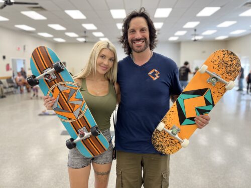 Ashley Jade Lussier et Mathieu Cyr, avec des planches à roulettes dans les main lors d'un évènement intérieur.