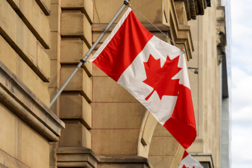 Un drapeau du Canada flotte, accroché à un édifice du gouvernement fédéral en Ontario.