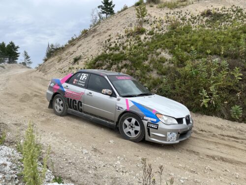 Une voiture de course du Rallye-X des Draveurs descend une côte en gravier dans une carrière à Blue Sea.
