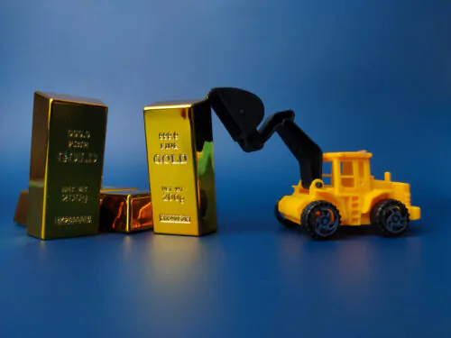 Excavator pushing gold bar on blue background. Business concept.