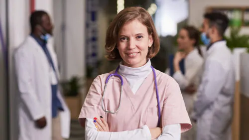 Young happy female general practitioner or nurse in medical scrubs