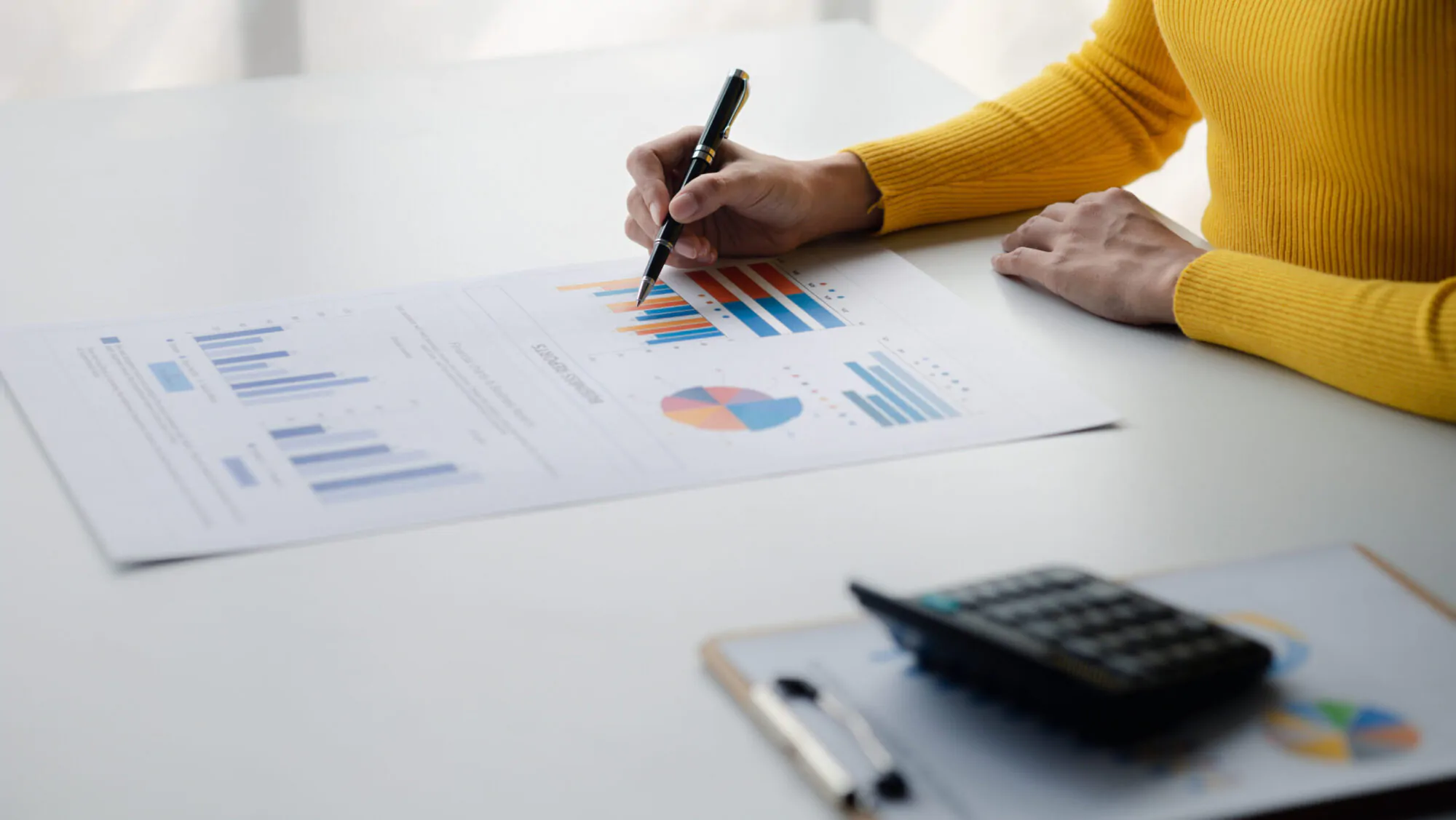 A female financier is reviewing company financial documents, mon