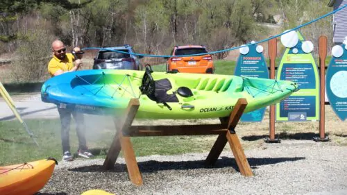 Un-homme-nettoie-un-kayak-scaled