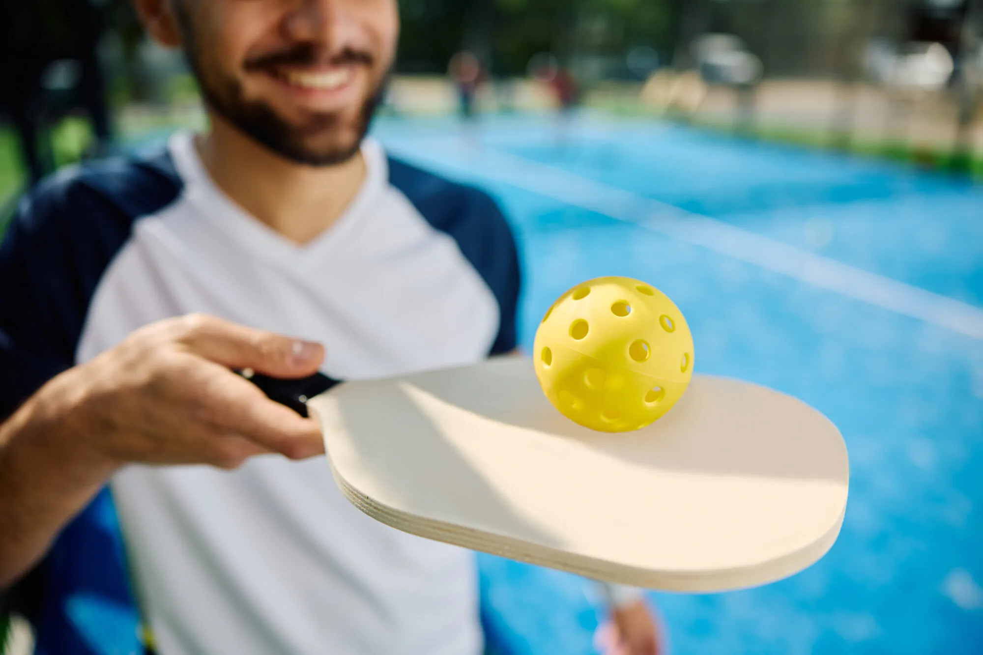 Homme avec équipement et sur un terrain de pickleball