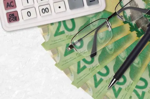 20 Canadian dollars bills fan and calculator with glasses and pen. Business loan or tax payment season concept