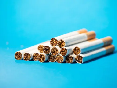 Closeup of tobacco cigarette filters on blue background