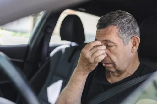 Tired pensioner dring in a car