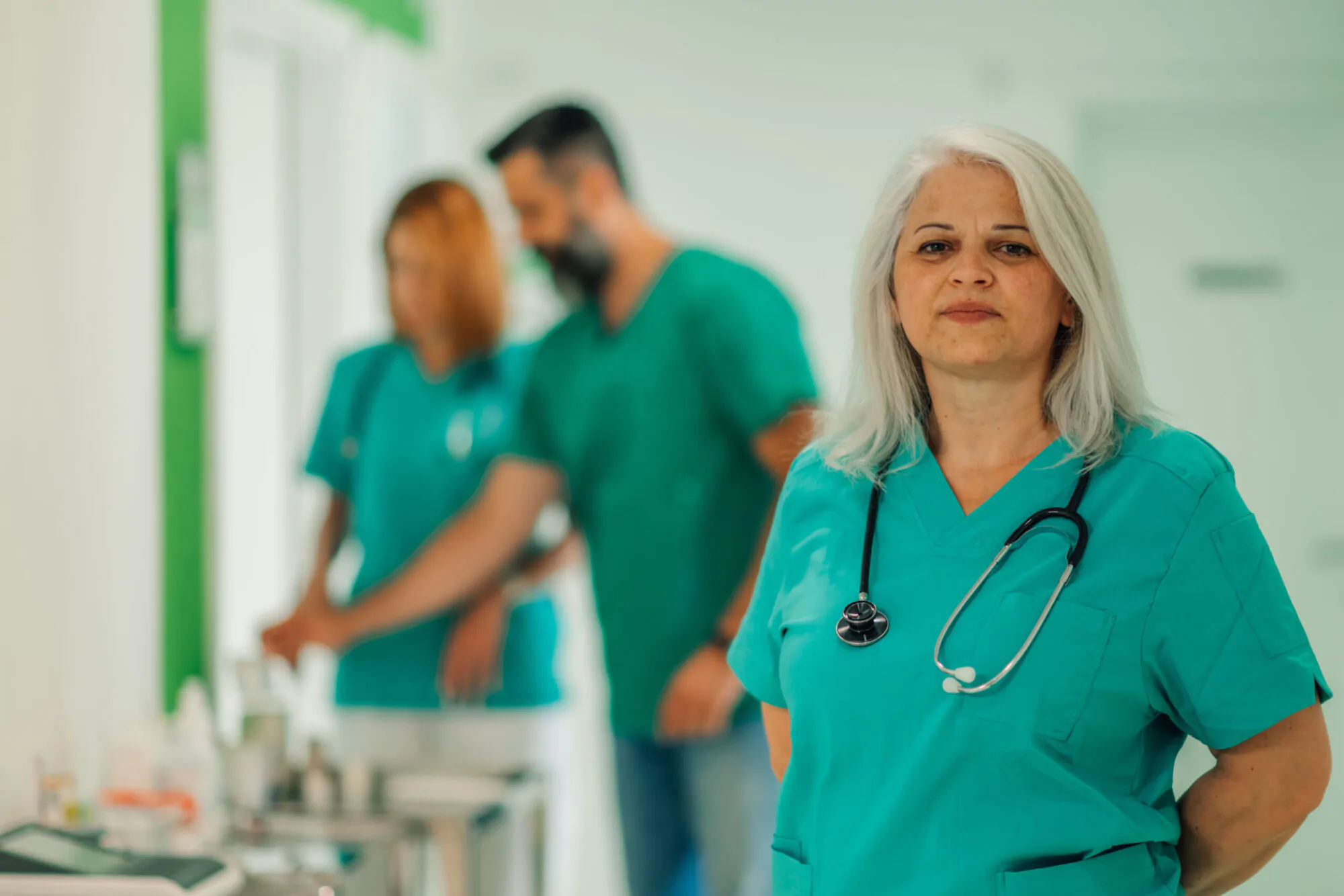 Female healthcare worker with arms crossed in hospital hallway