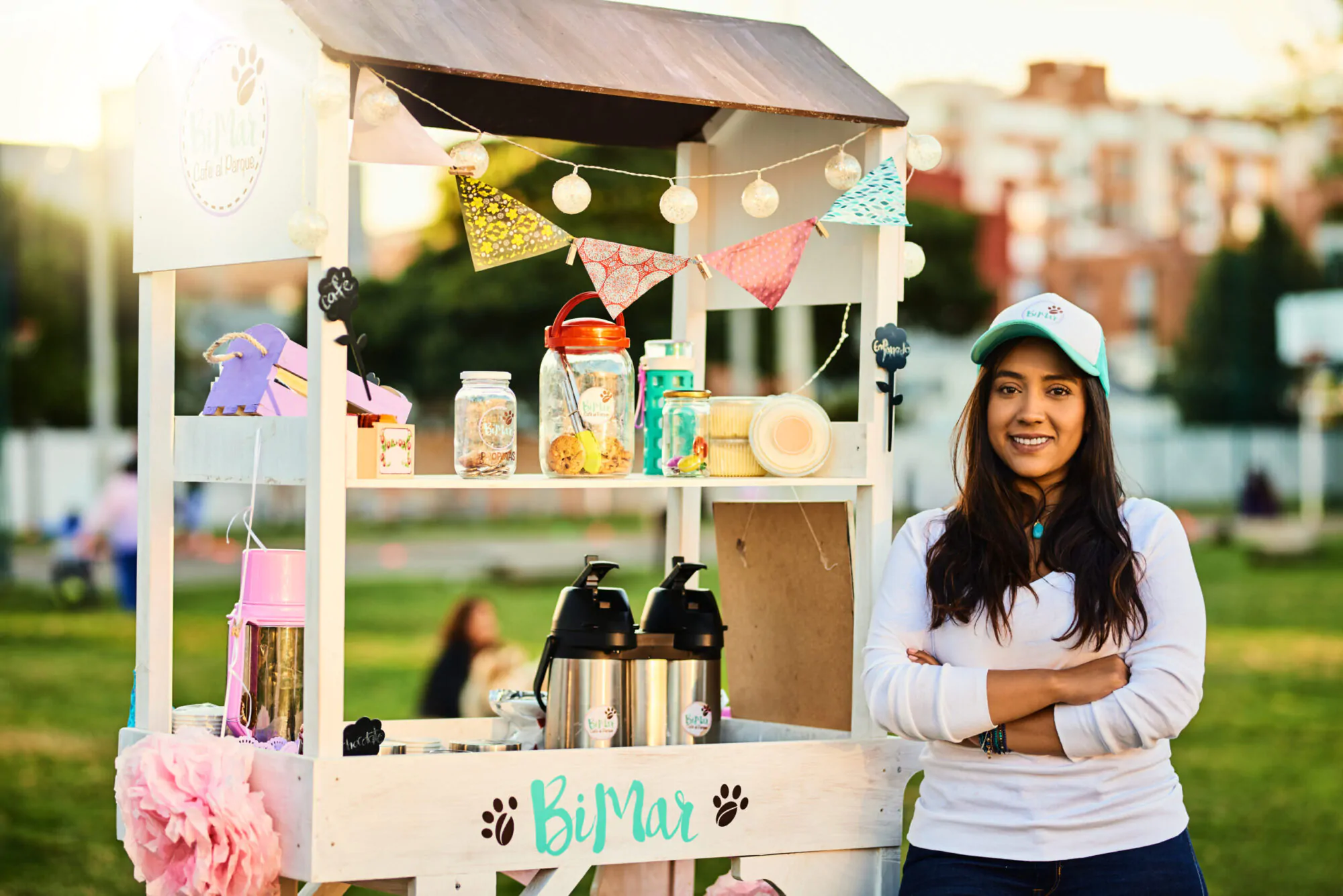 Adolescente avec casquette blanche et cheveux longs bruns, kiosque extérieur en bois, limonade, thé glacé à vendre