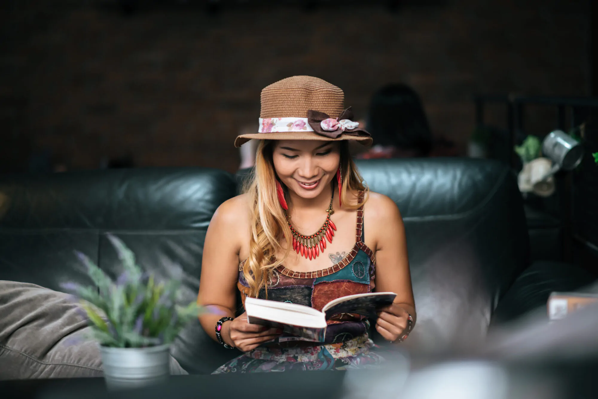 Young woman reading book and fresh cup of coffee on the table
