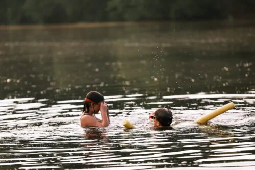 Deux enfants se baignent dans un lac.