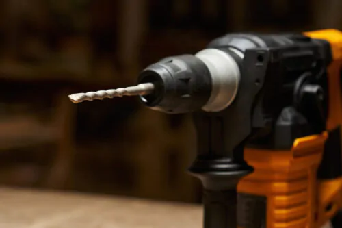 close-up and focus on the carbide tip of a drill bit inserted into a quick-change chuck