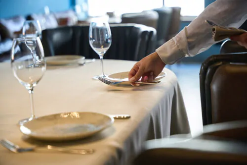 Waitress in a restaurant lays out cutlery