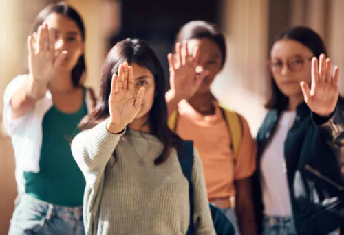 Un groupe de jeunes femmes lève la main droite en signe de protestation.