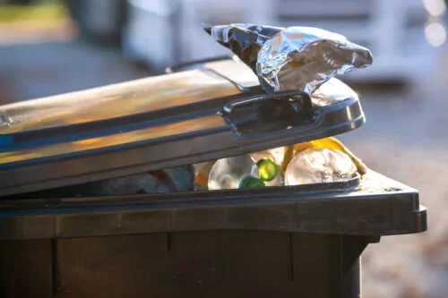 Gros plan sur un bac noir rempli de déchets.