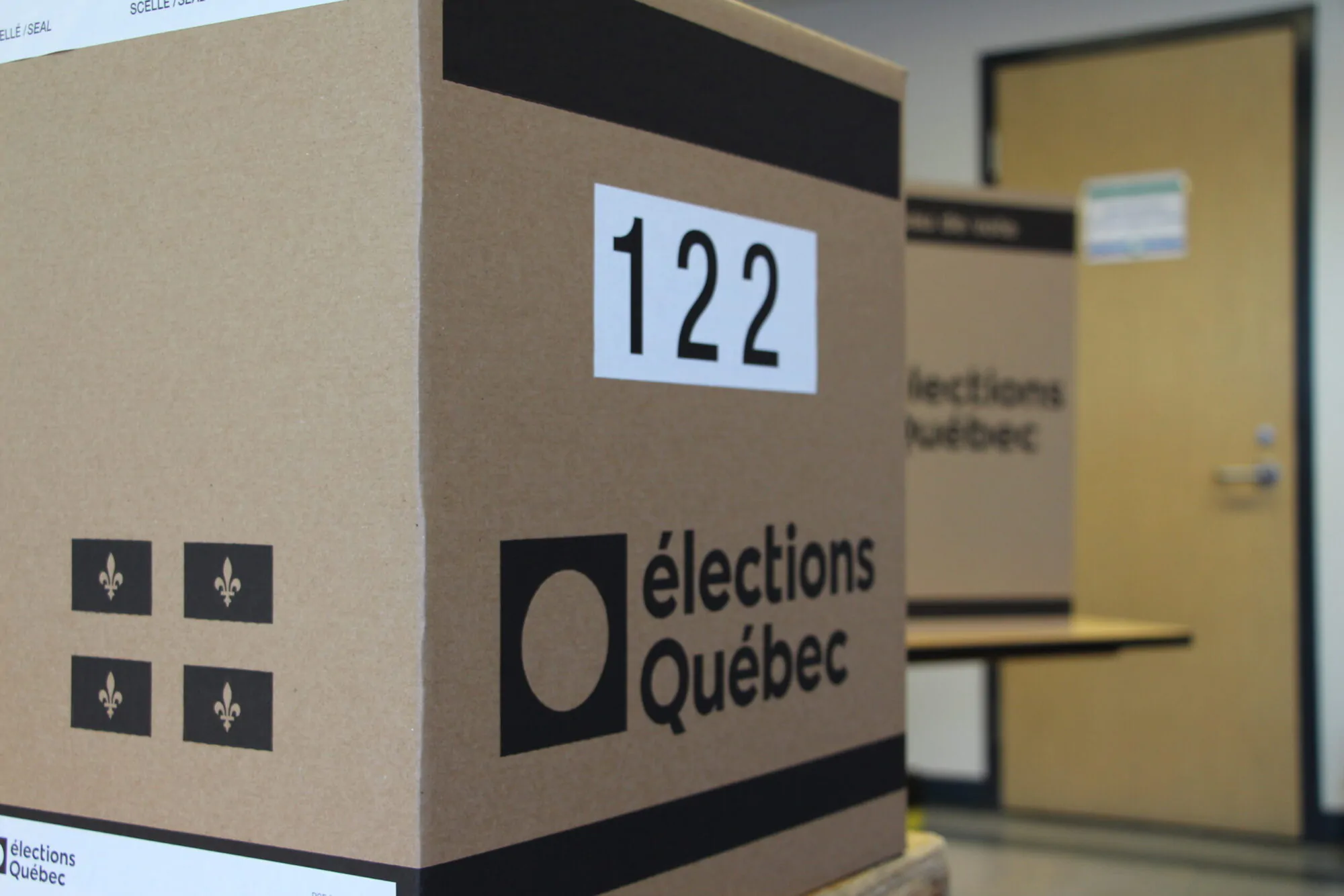 Une urne d'Élections Québec posée sur une table dans une salle.