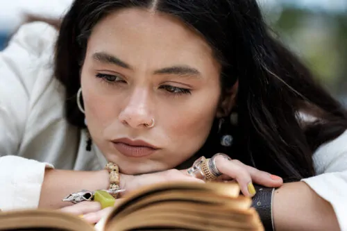 Close portrait of woman reading fascinating book.