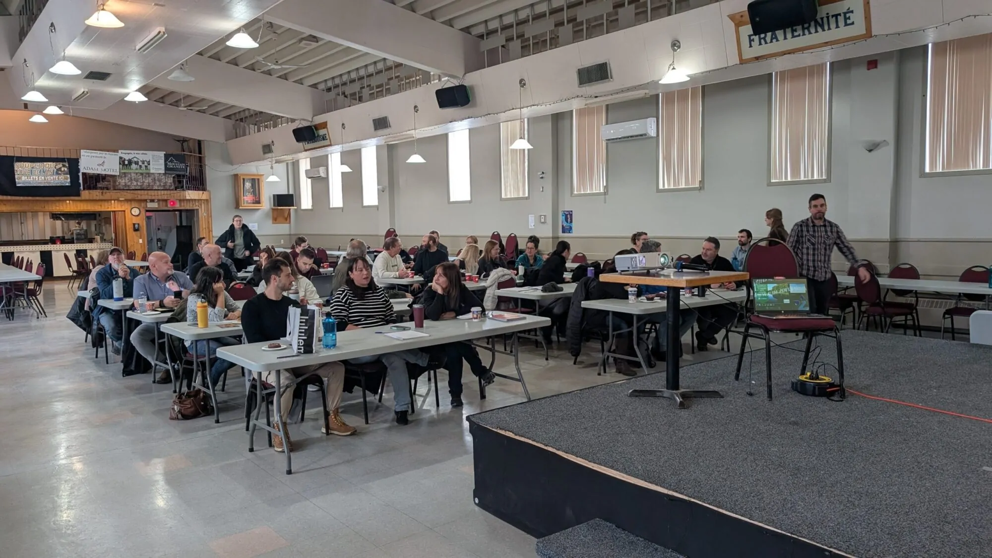 des participants à une formation sont réunis dans une grande salle où ils sont assis.